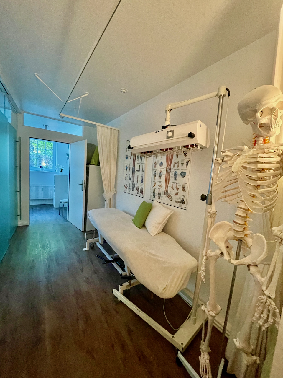 Behandlungsraum mit Therapieliege und Skelettmodell